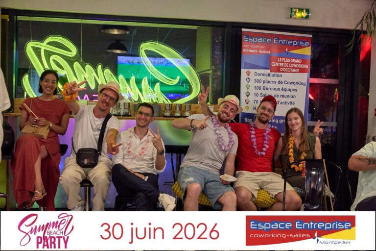 Groupe de participants posant devant l'enseigne néon de la Summer Beach Party à Espace Entreprise Garosud